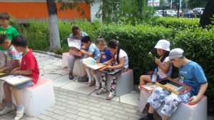 Uni Librarian sits with a child during reading time - promoting literacy.