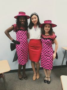 Students pose in costume behind the scenes of the high school musical